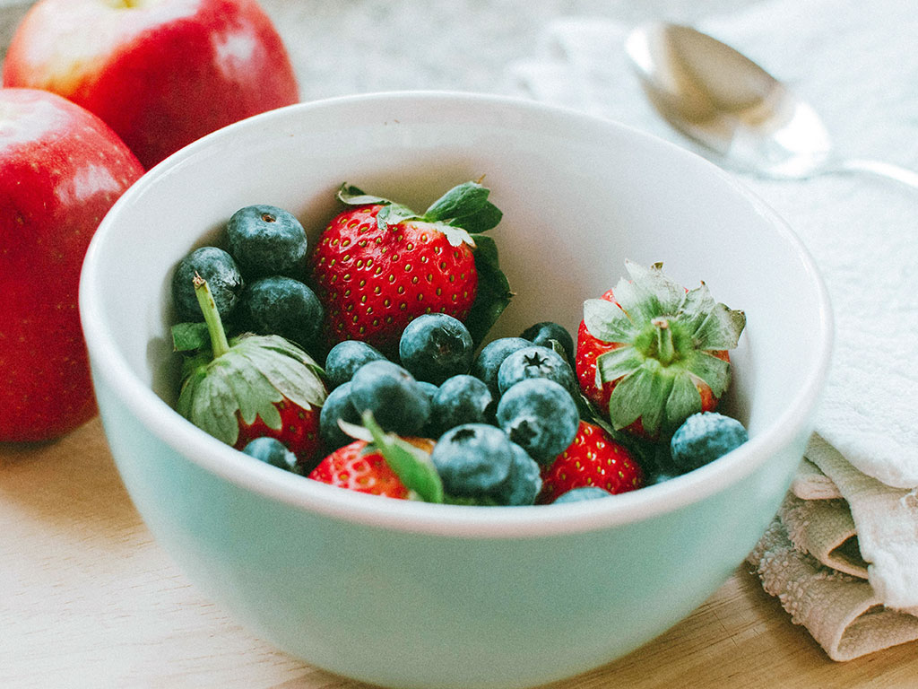 Eine Porzellanschale mit Erdbeeren und Heidelbeeren