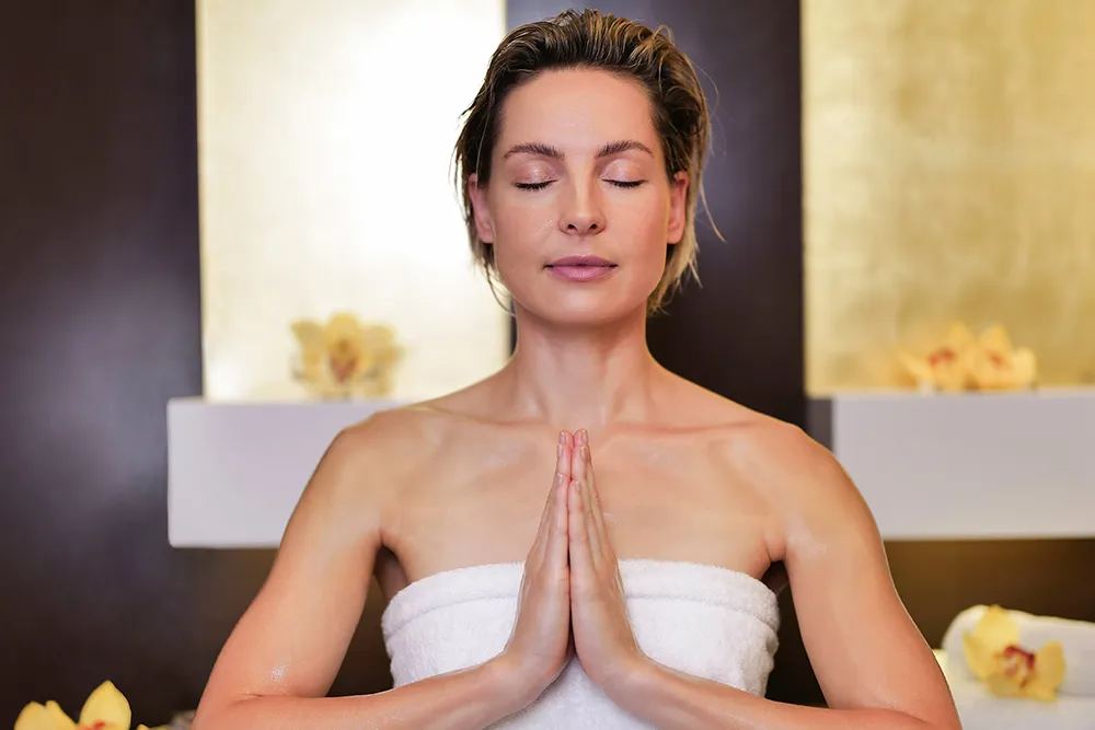 Frau meditiert nach einer ayurvedischen Behandlung